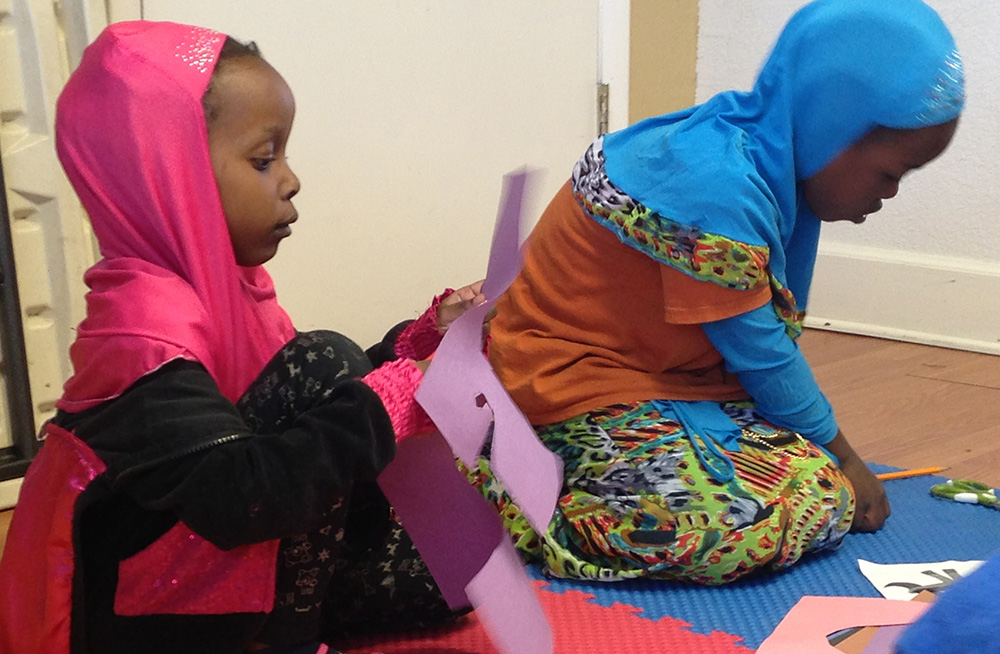 Two Somali girls cutting paper for their illustrations