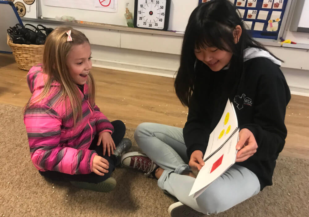 Kotomi reading her book to a first-grade student