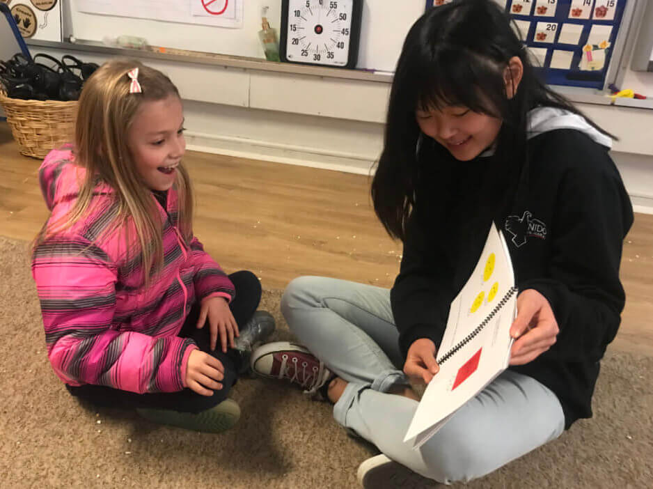 Kotomi reading her book to a first-grade student