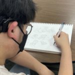 student drawing manga for their book