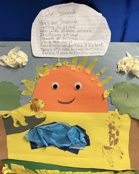 A colorful artwork featuring a poem titled "Our Savannah" written on lined paper at the top. Below the poem is a vibrant collage depicting a savannah landscape. The collage includes a smiling orange sun with googly eyes, a blue pond made of tissue paper, and cutout animals—a lion and a giraffe—set against a grassy background with trees.